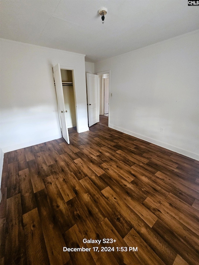 unfurnished bedroom featuring dark hardwood / wood-style flooring and a closet