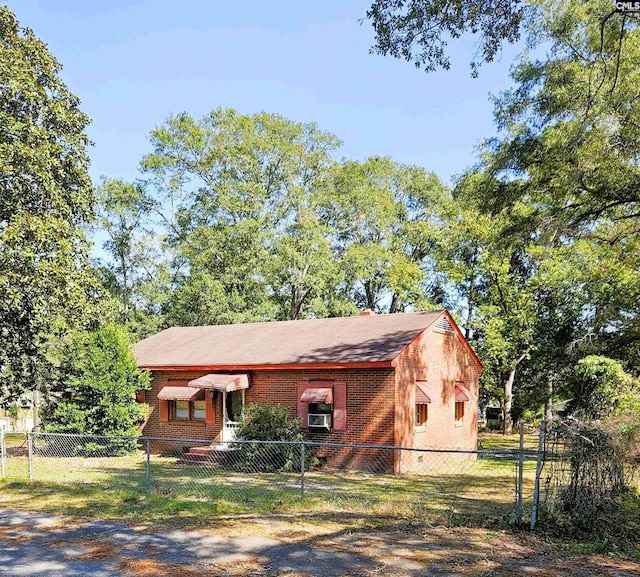 view of front facade featuring brick siding and a fenced front yard