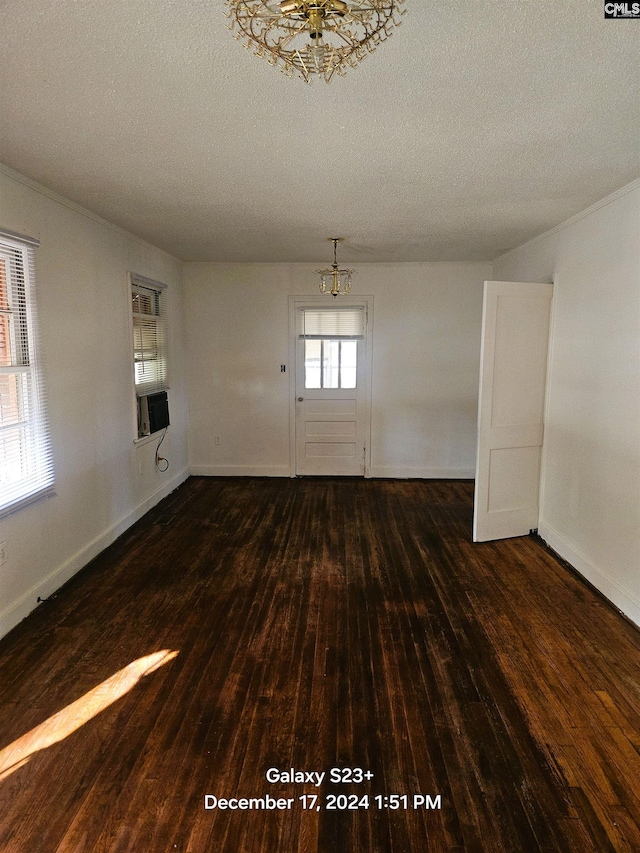 unfurnished room featuring dark hardwood / wood-style floors, a textured ceiling, and a chandelier