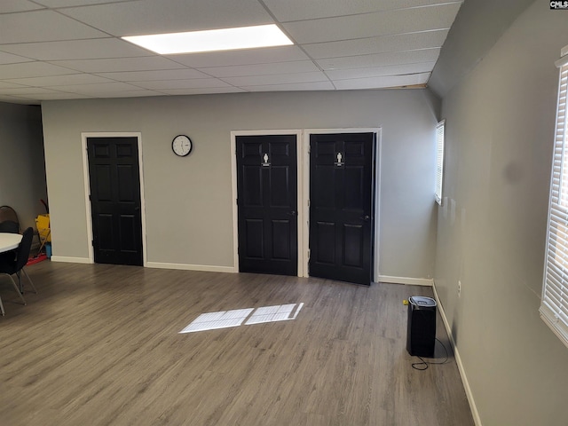 empty room featuring a drop ceiling and light hardwood / wood-style floors