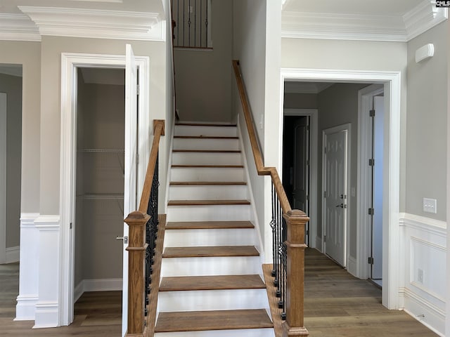 stairs featuring hardwood / wood-style floors and ornamental molding