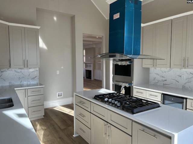 kitchen featuring island exhaust hood, decorative backsplash, ornamental molding, and gas cooktop