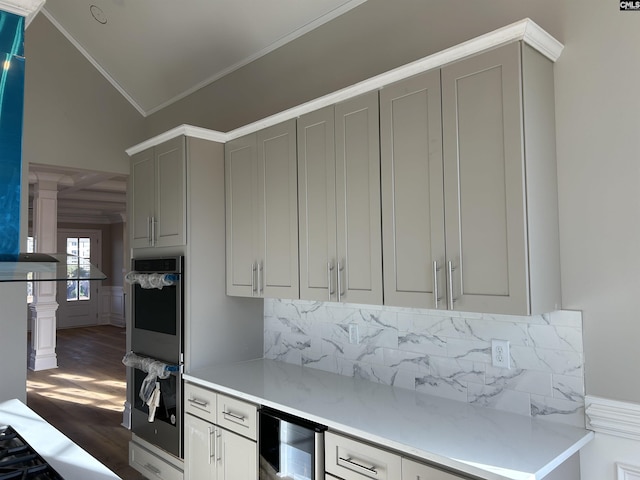 kitchen with backsplash, vaulted ceiling, ornamental molding, dark hardwood / wood-style flooring, and beverage cooler