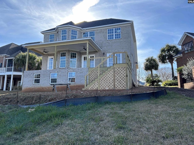 back of property with ceiling fan and a lawn