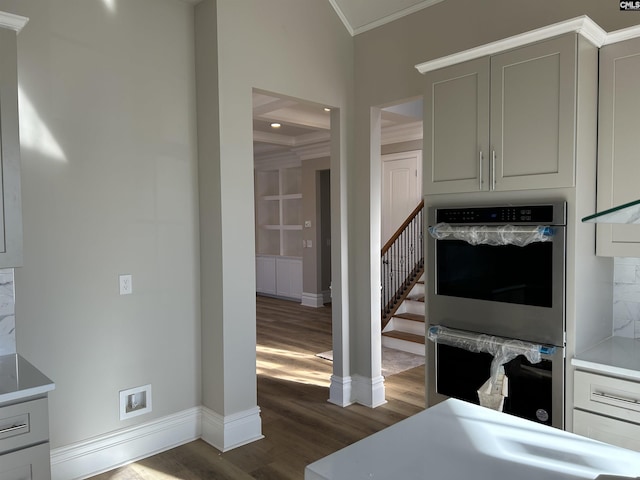 interior space with decorative backsplash, dark hardwood / wood-style floors, double oven, and ornamental molding