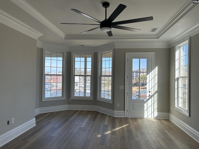 unfurnished room featuring ornamental molding, a tray ceiling, ceiling fan, and dark wood-type flooring