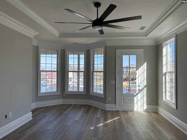 empty room featuring a healthy amount of sunlight, dark hardwood / wood-style floors, and ornamental molding