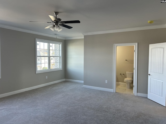 unfurnished bedroom featuring ceiling fan, ensuite bathroom, crown molding, and light carpet