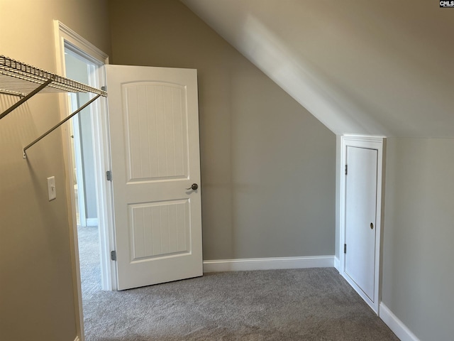 additional living space featuring carpet and vaulted ceiling