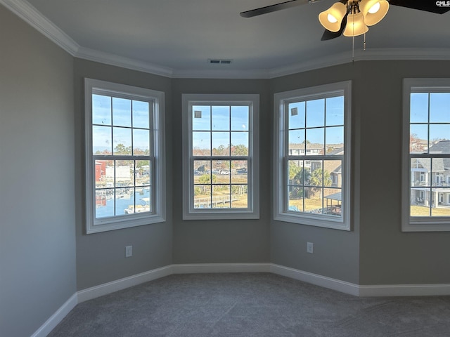 carpeted empty room with ceiling fan and crown molding