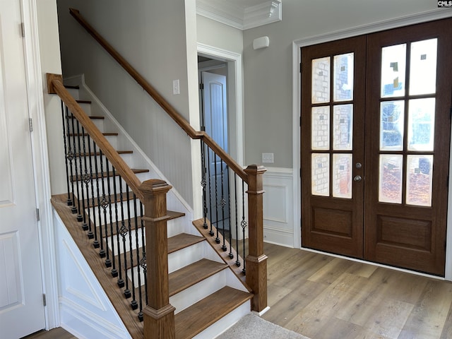 foyer entrance featuring french doors, light wood-type flooring, and crown molding