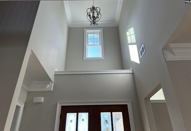 interior space featuring french doors, an inviting chandelier, and ornamental molding