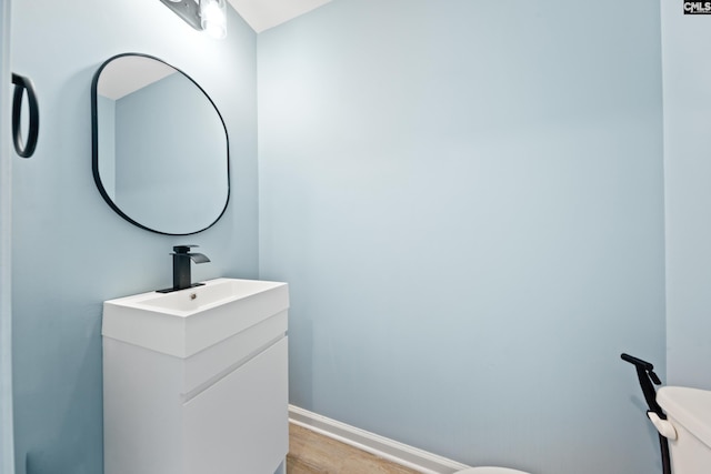 bathroom featuring hardwood / wood-style floors, vanity, and toilet