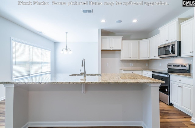 kitchen featuring appliances with stainless steel finishes, white cabinetry, a kitchen island with sink, and sink