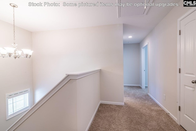 hall with carpet and an inviting chandelier