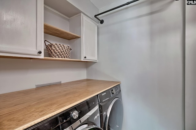 laundry area featuring cabinets and washer and clothes dryer