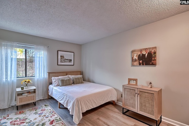 bedroom featuring a textured ceiling and hardwood / wood-style flooring