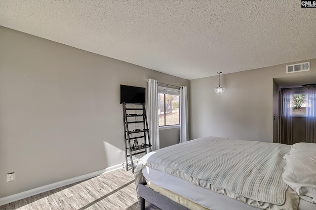 bedroom featuring hardwood / wood-style floors and a textured ceiling