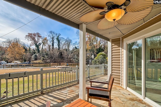 wooden terrace with ceiling fan and a yard