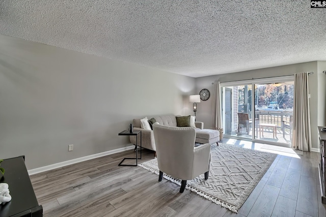 living room with a textured ceiling and light hardwood / wood-style flooring