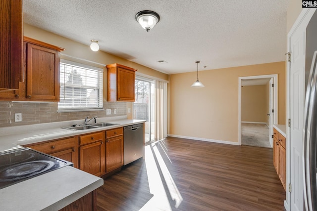 kitchen featuring tasteful backsplash, stainless steel dishwasher, dark wood-type flooring, sink, and hanging light fixtures