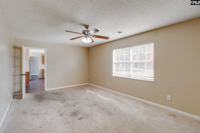 carpeted empty room featuring a textured ceiling and ceiling fan