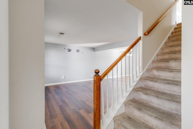 staircase with hardwood / wood-style floors