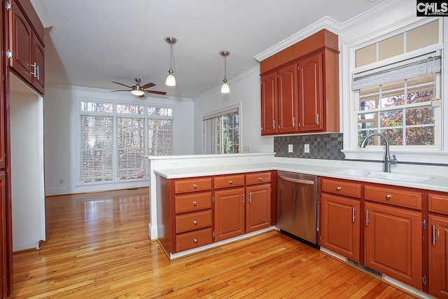 kitchen featuring dishwasher, pendant lighting, light wood-type flooring, and a wealth of natural light