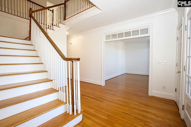 staircase featuring hardwood / wood-style flooring and crown molding