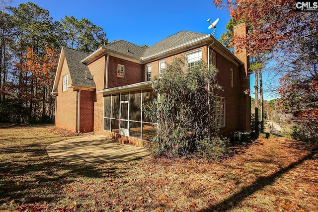 back of property with a patio area and a sunroom