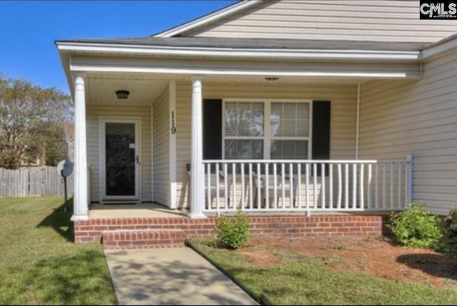 property entrance featuring a porch and a yard