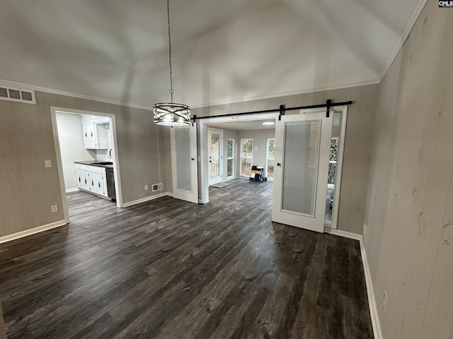 unfurnished dining area featuring vaulted ceiling, crown molding, a barn door, and dark hardwood / wood-style flooring