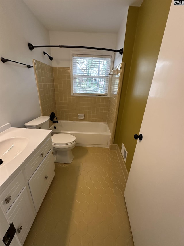 full bathroom featuring toilet, vanity, tile patterned floors, and tiled shower / bath