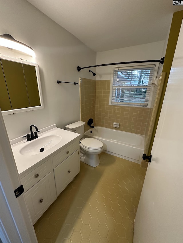 full bathroom with tiled shower / bath combo, vanity, tile patterned flooring, and toilet