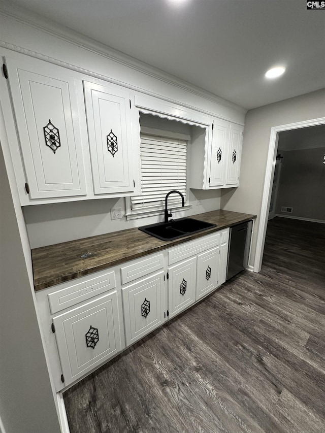 kitchen with sink, white cabinets, dark wood-type flooring, and stainless steel dishwasher