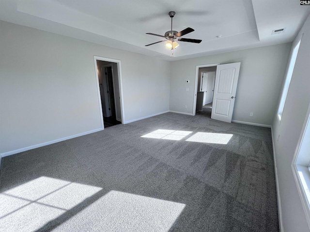 spare room featuring dark colored carpet and ceiling fan