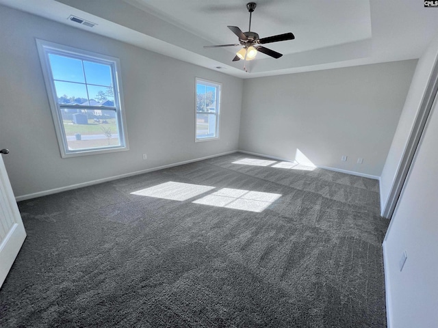 carpeted empty room with a tray ceiling and ceiling fan