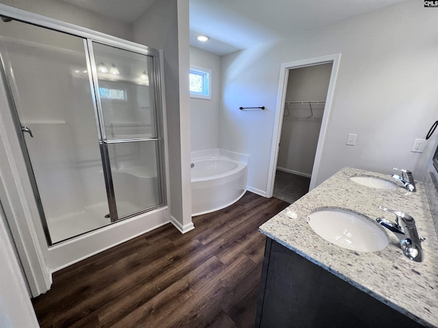 bathroom with hardwood / wood-style floors, vanity, and independent shower and bath