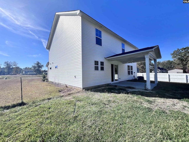 back of property with a patio area and a lawn