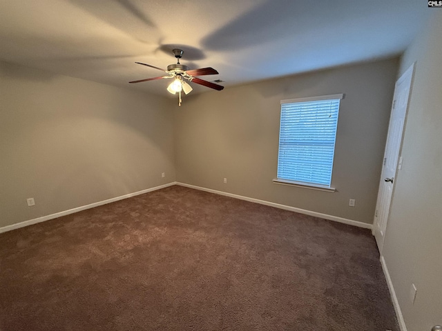 unfurnished room with dark carpet and ceiling fan