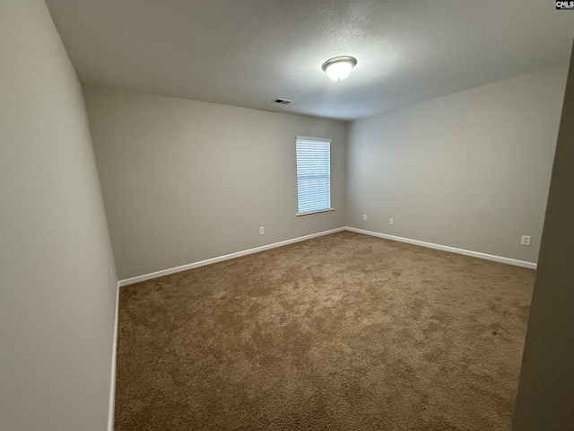 carpeted empty room featuring a textured ceiling