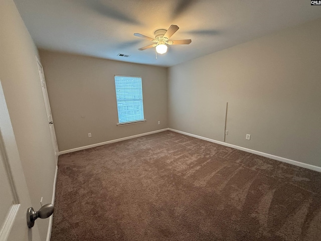 spare room with ceiling fan and dark carpet