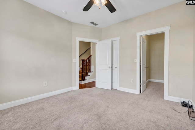 unfurnished bedroom featuring ceiling fan and light colored carpet