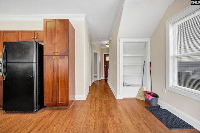 kitchen with black refrigerator, light hardwood / wood-style floors, and ornamental molding