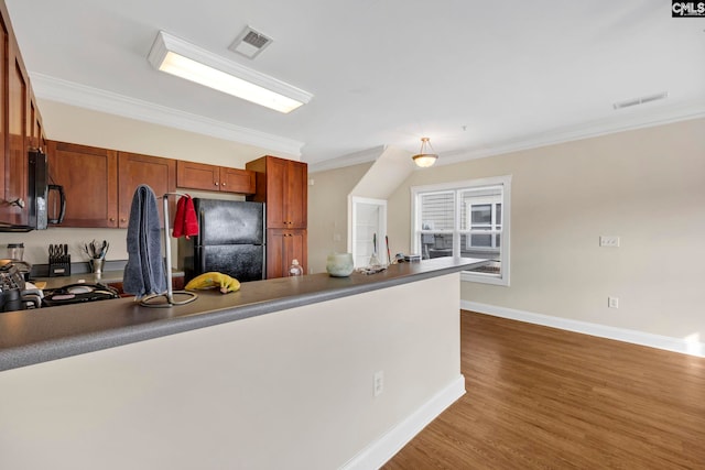 kitchen with wood-type flooring, crown molding, and black appliances