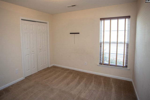 unfurnished bedroom featuring carpet flooring and a closet