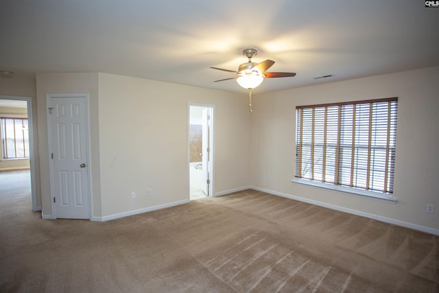 carpeted spare room featuring ceiling fan