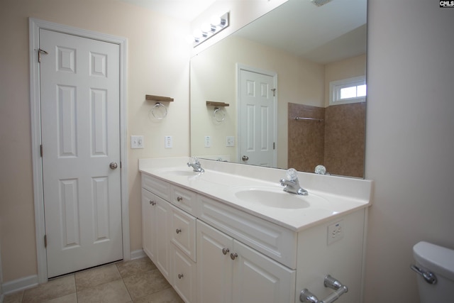 bathroom with tile patterned flooring, vanity, and toilet