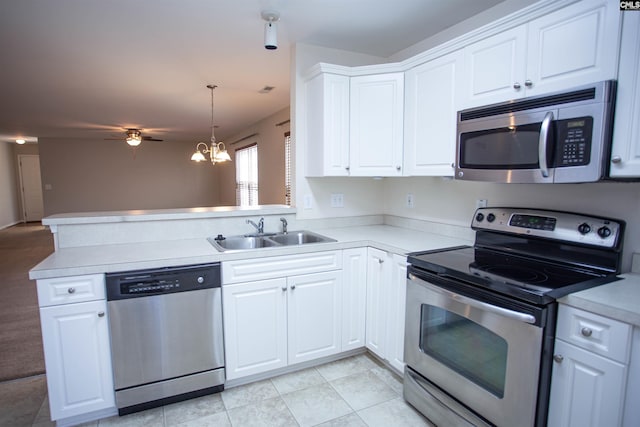 kitchen featuring white cabinetry, sink, hanging light fixtures, kitchen peninsula, and appliances with stainless steel finishes