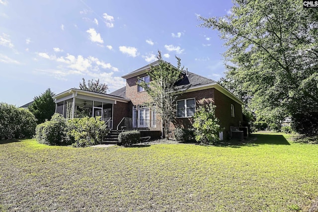 view of front of property with a sunroom, a front lawn, and central AC unit